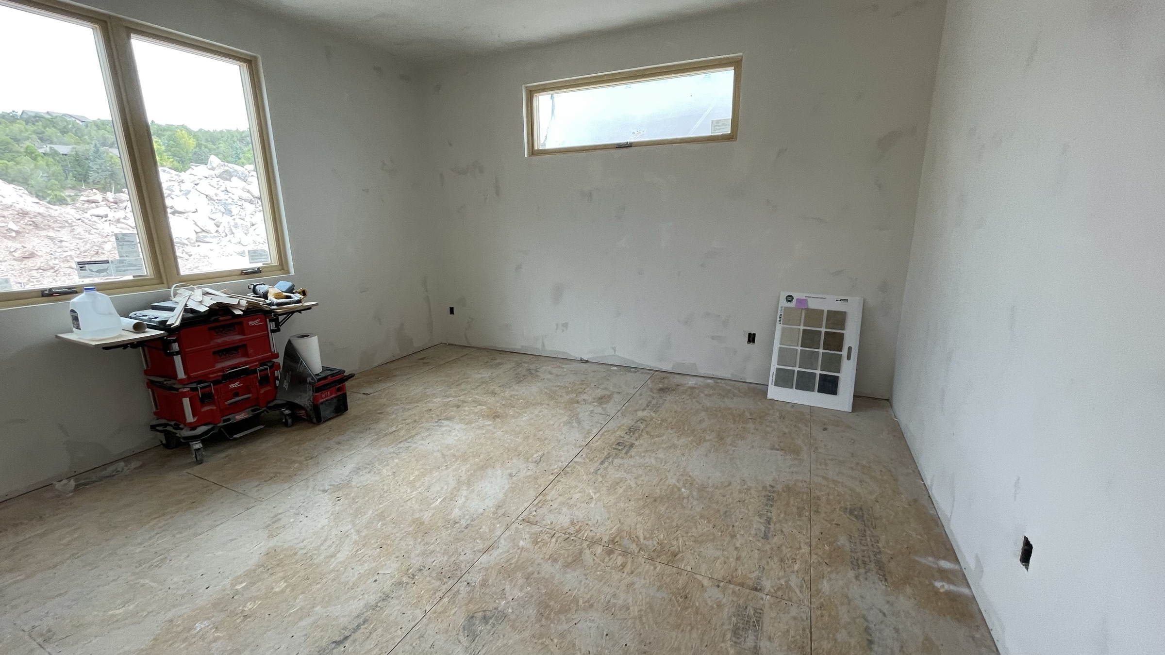 Guest bedroom with dual windows, drywall complete — July 26, 2026