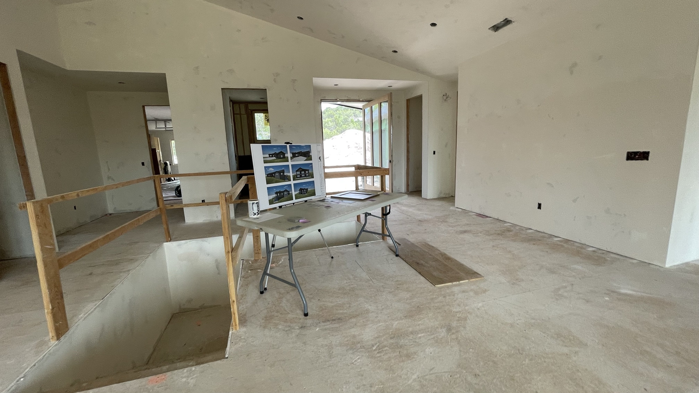 Stairwell and entry door on the main level, drywall complete — July 26, 2026