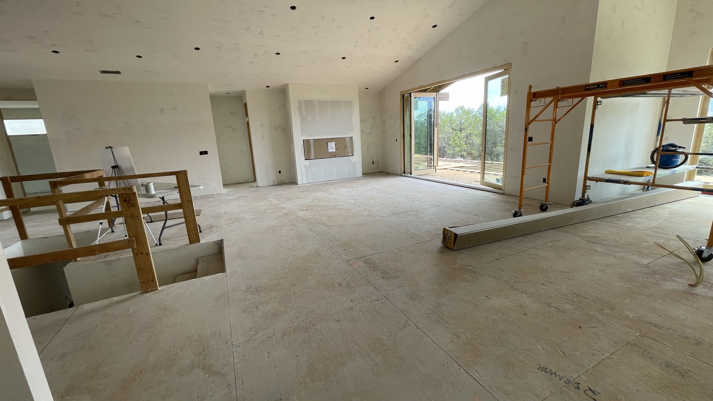 Great room and open stairwell to the walk-out lower level, drywall complete — July 26, 2026