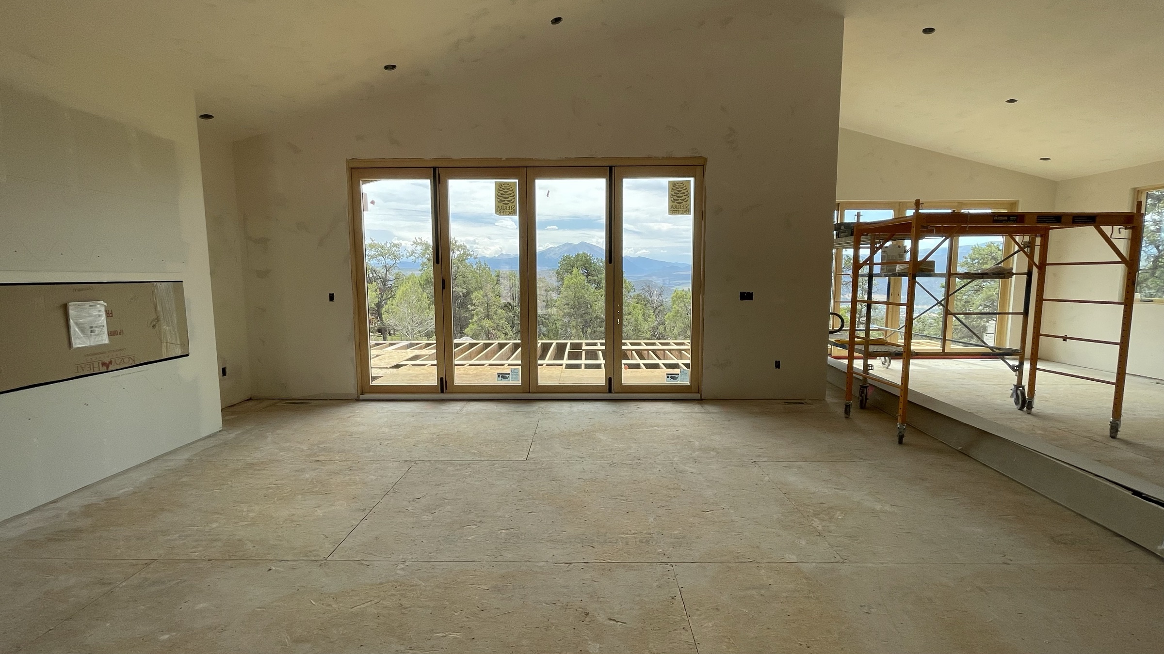 Great room view with sliding door and valley views, drywall complete — July 26, 2026