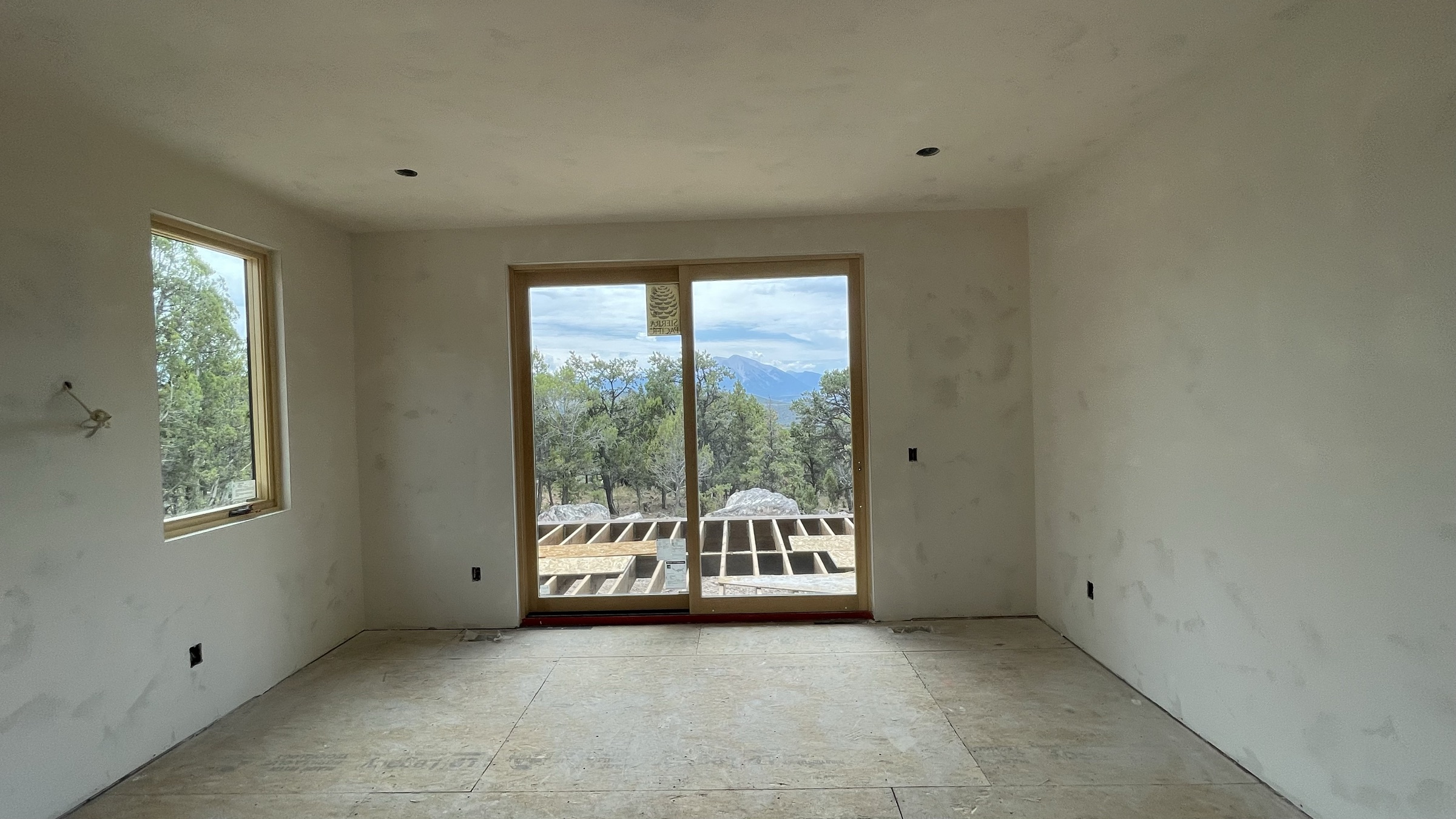 Primary suite with sliding door to the deck and Mt. Sopris views, drywall complete — July 26, 2026