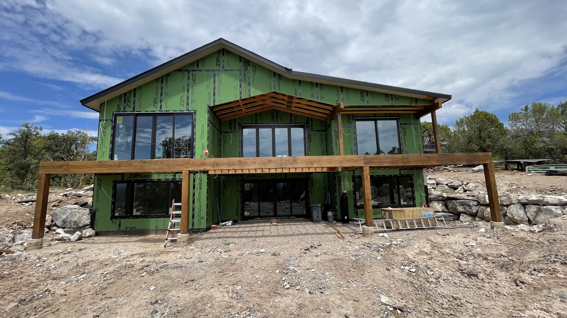 Rear elevation with deck beams installed and walls of windows — July 26, 2026
